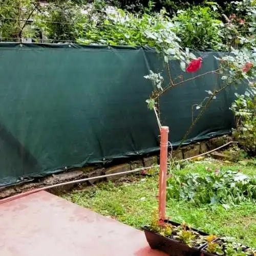 lona reforçada verde instalada na cerda de jardim para impedir visibilidade