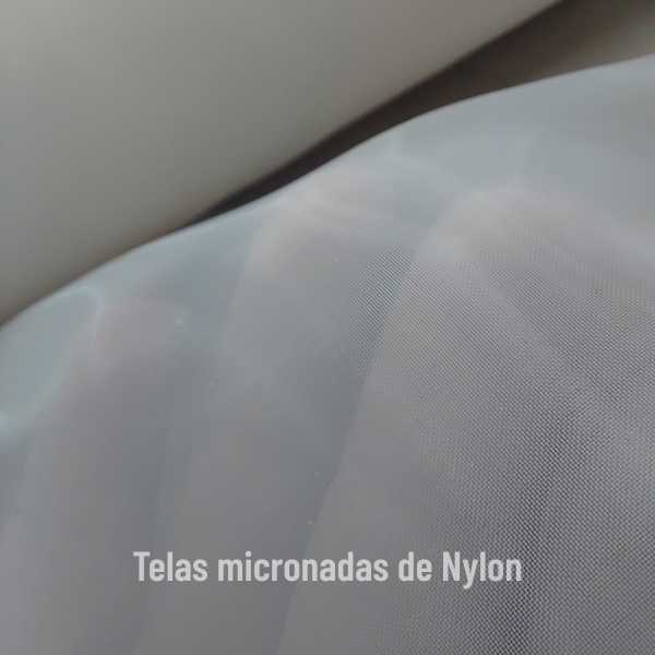 Tela micronada de nylon em close, mostrando a trama fina e translúcida do tecido, com a frase “Telas micronadas de Nylon” na parte inferior