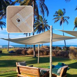 Tela shade bege instalada em área externa com estrutura de postes, proporcionando sombreamento em espaço de lazer ao ar livre com coqueiros e mobiliário de madeira.